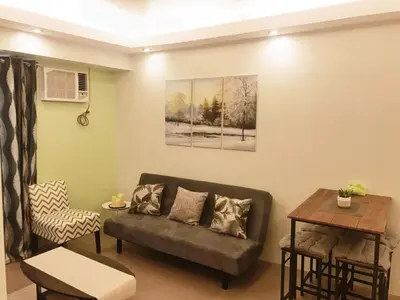 a living room with a couch and a table at 1 BR Condo in Quezon City at Avida New Manila in Manila