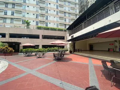 a patio with tables and chairs and umbrellas in a building at 1 BR Condo in Quezon City at Avida New Manila in Manila