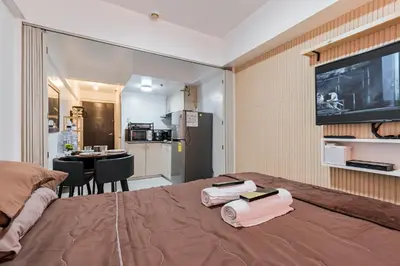 a bedroom with a bed with two towels on it at Prime Studio Unit at Robinson Magnolia 5 mins Walk to Mall-Netflix-KTV-WiFi in Manila