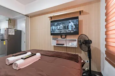 a room with a television and a bed with a fan at Prime Studio Unit at Robinson Magnolia 5 mins Walk to Mall-Netflix-KTV-WiFi in Manila