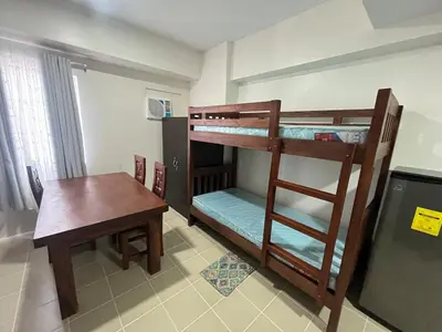 a room with two bunk beds and a table at Covent Garden Condo 2117 in Manila