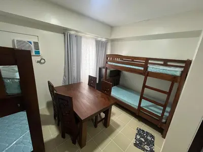 a small room with a table and bunk beds at Covent Garden Condo 2117 in Manila