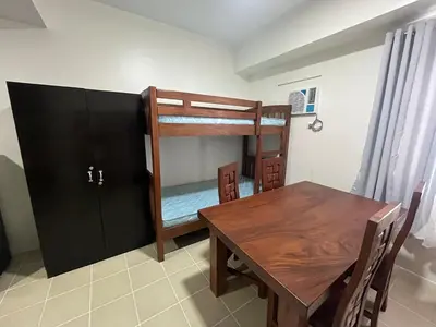 a dining room with a table and a bunk bed at Covent Garden Condo 2117 in Manila