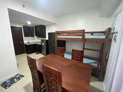 a kitchen and dining room with a table and bunk beds at Covent Garden Condo 2117 in Manila