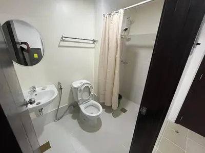a bathroom with a toilet and a sink and a mirror at Covent Garden Condo 2117 in Manila