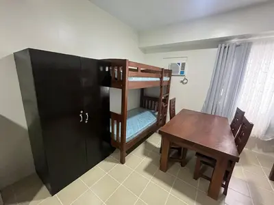 a room with a table and a bunk bed and a table and chair at Covent Garden Condo 2117 in Manila