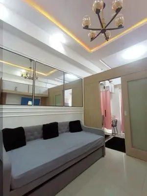 a living room with a couch and a chandelier at Cozy room for couple and family near mall of asia in Manila
