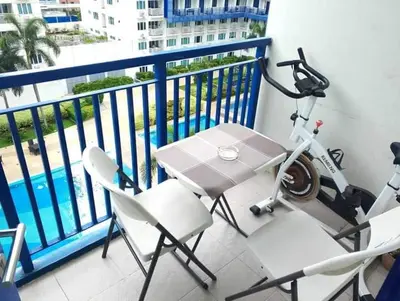 a balcony with a bike and a table and chairs at Verlyn Place At Sea Residences Near Moa in Manila