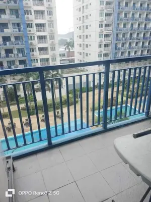 a balcony with a blue railing and some buildings at Verlyn Place At Sea Residences Near Moa in Manila