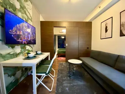 a living room with a couch and a table at Air Residence Makati Cozy City View in Manila