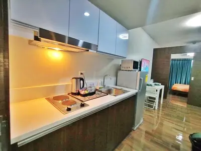 a kitchen with a sink and a refrigerator at Air Residence Makati Cozy City View in Manila