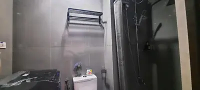 a bathroom with a shower and a toilet and a sink at Air Residence Makati Cozy City View in Manila