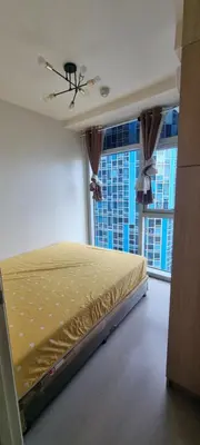 a bed in a room with a large window at Rikki Staycation in Manila