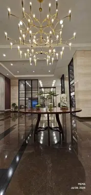 a dining table in a lobby with a chandelier at Relaxation Getaway in Manila