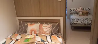 a bedroom with a bed with a rainbow pillow at Shore Tower B in Manila