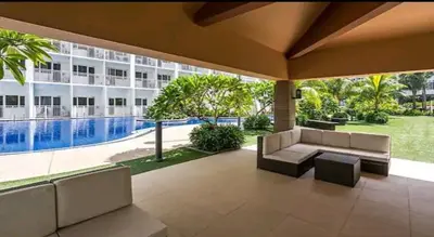 a patio with a couch and a pool in front of a building at Shore Tower B in Manila