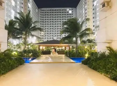 a large building with palm trees in front of it at Shore Tower B in Manila