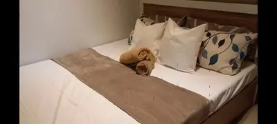 a bed with white sheets and pillows with towels on it at Shore Tower B in Manila