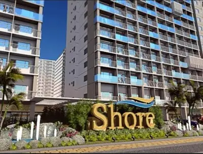 a store sign in front of a large building at Shore Tower B in Manila