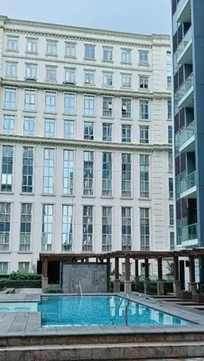 a large building with a swimming pool in front of it at Budget Stay Across NAIA Terminal 3 C3-3G in Manila