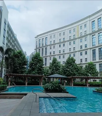a large building with a swimming pool in front of a building at Budget Stay Across NAIA Terminal 3 C3-3G in Manila