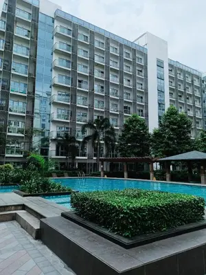 a large building with a swimming pool in front of it at Budget Stay Across NAIA TERMINAL 3 C2-5J in Manila
