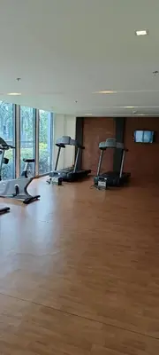 a gym with several treadmills in a large room with wood floors at Budget Stay Across NAIA TERMINAL 3 C2-5J in Manila