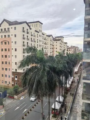 a city street with a palm tree and buildings at Budget Stay Across NAIA TERMINAL 3 C2-5J in Manila