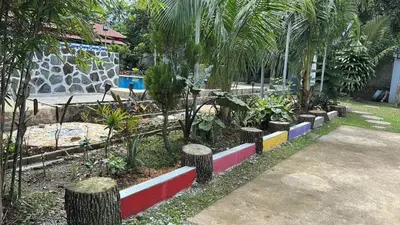 a garden with trees and plants in a yard at Lenjawi Resort and Events Place in Bitangan