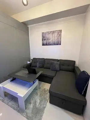a living room with a couch and a table at Chino Roces Makati - Free Parking - Red Residences in Manila