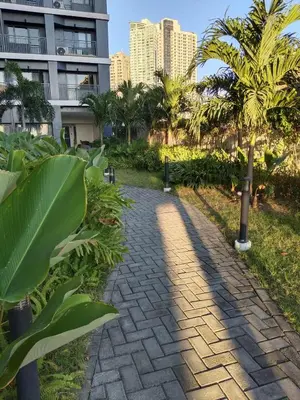 a brick pathway with palm trees and a building at Chino Roces Makati - Free Parking - Red Residences in Manila