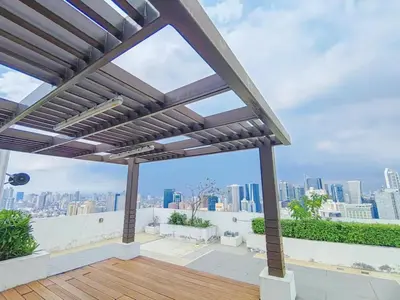 a pergola on a roof with a view of the city at The Beacon Condo at Makati CBD in Manila