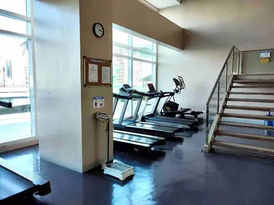 a gym with treadmills and stairs in a building at The Beacon Condo at Makati CBD in Manila