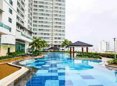 a swimming pool in front of a tall building at The Beacon Condo at Makati CBD in Manila
