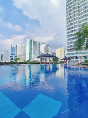 a swimming pool with a city skyline in the background at The Beacon Condo at Makati CBD in Manila