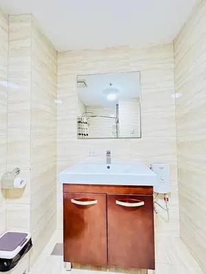 a bathroom with a sink and a mirror at Ace Suites by the WaterSpa - Budget Family Room in Manila