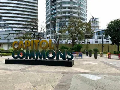 a large metal sign in a city with buildings at Ace Suites by the WaterSpa - Budget Family Room in Manila