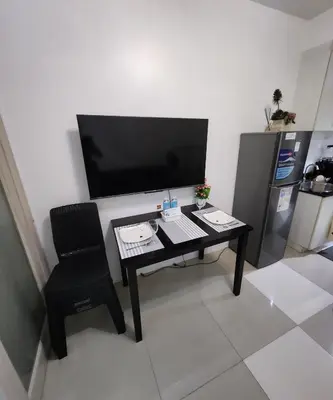 a black desk with a chair and a flat screen tv at MNM Place - Sea Residence 0D in Manila