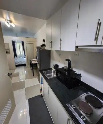 a small kitchen with a sink and a stove at MNM Place - Sea Residence 0D in Manila