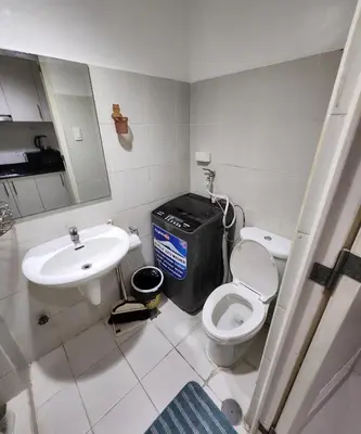 a bathroom with a toilet and a sink at MNM Place - Sea Residence 0D in Manila