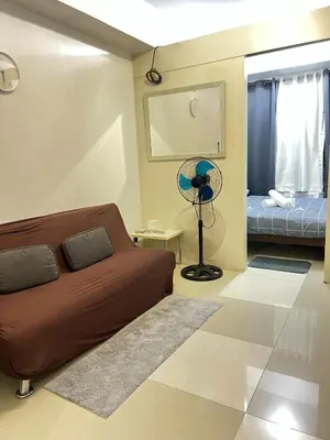 a bedroom with a bed and a window and a fan at MNM Place - Sea Residence 0D in Manila
