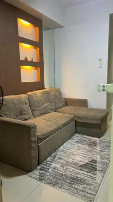 a living room with a brown couch and a rug at MNM Place - Sea Residence 5A in Manila