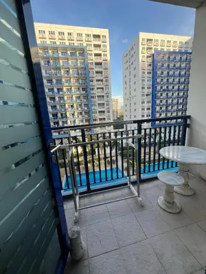 a balcony with a table and views of buildings at MNM Place - Sea Residence 5A in Manila