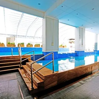 a large swimming pool with blue water in a building at 3 Bedroom Beautiful and Spacious Penthouse in Makati in Manila