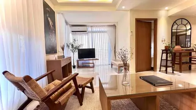 a living room with a table and a television at 3 Bedroom Beautiful and Spacious Penthouse in Makati in Manila