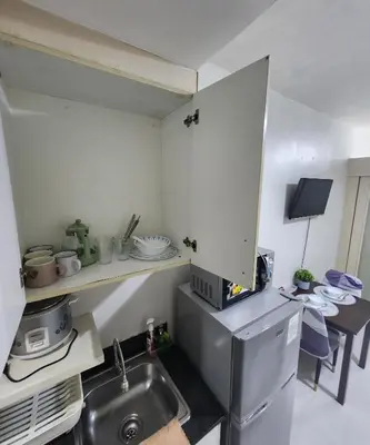 a small kitchen with a sink and a table at MNM Place - Sea Residence 9A in Manila