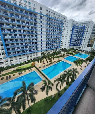 an aerial view of a hotel with two pools and palm trees at MNM Place - Sea Residence 9A in Manila