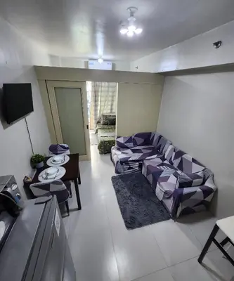 a living room with a couch and a table at MNM Place - Sea Residence 9A in Manila