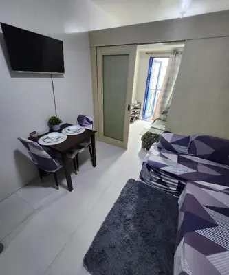 a living room with a table and a tv at MNM Place - Sea Residence 9A in Manila