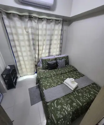 a small room with two beds and a window at MNM Place - Sea Residence 9A in Manila
